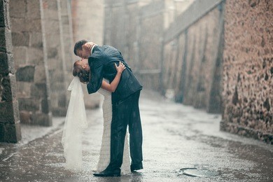 beautiful wedding couple kissing in the rain