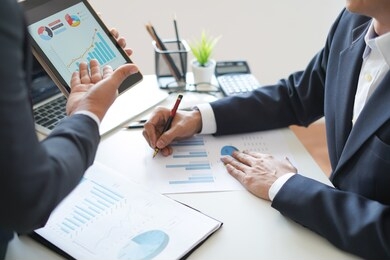 businessman is discussing, advice or reporting about company profit, sale volume chart and data analysis graph to supervisor or ceo in the meeting with smart device, business and financial concept