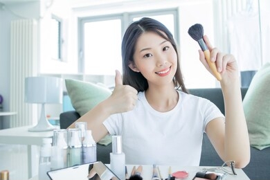 young beautiful woman making make-up near mirror,sitting at the desk