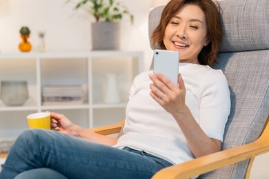 asian senior age woman who uses smart phone