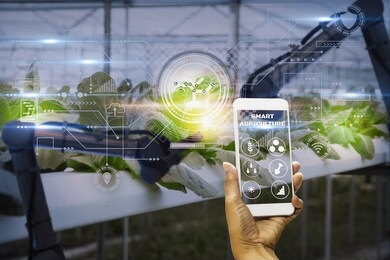 smart farmer using smartphone with artificial intelligence or ai technology,system control robot,use robotic arm inspect quality and harvest agricultural product,satellite track technology agriculture