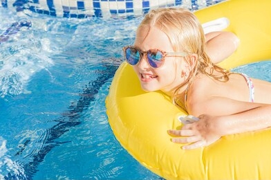 summertime fun. pretty little girl swimming in outdoor pool 