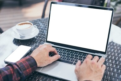 computer,cell phone mockup image blank screen with white background for advertising,hand man work using laptop texting mobile contact business search information on desk in cafe.marketing,design