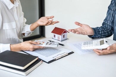 real estate broker agent being analysis and making the decision a home estate loan to customer, agent man is using calculator to presentation detail and waiting for his reply to finish.