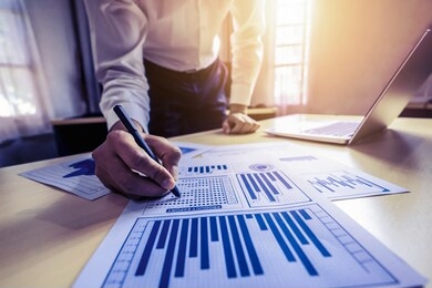businessman accountant or financial expert analyze business report graph and finance chart at corporate office. concept of finance economy, banking business and stock market research.
