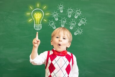 bright idea! surprised child student pointing finger up! happy kid against green chalkboard. online education and e-learning concept. back to school