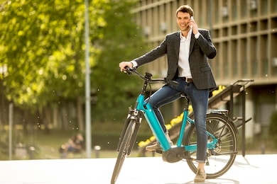 handsome young businessman on the ebike using mobile phone
