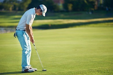 golf man putting on green for birdie while on vacation
