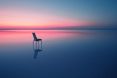 chair among smooth water of lake at the sunset. the concept of solitude and unity with nature. a chair stands in the water of the salt lake ace. anatolia, turkey