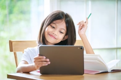 asian little girl taking class on line and happy for homeschool quarantine coranavirus pandemic concept