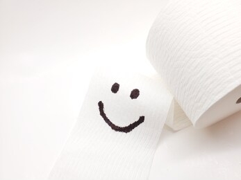 symbol happy smile face on toilet paper. image in selective focus. happy concept.