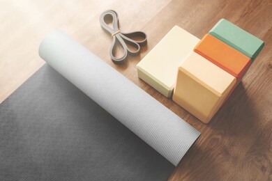 beautiful yoga equipment composition of mat, bricks and rubber band. morning mood, sunlight