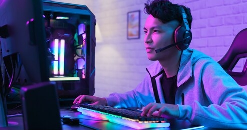 young asian handsome pro gamer playing in online cyber sport game at home