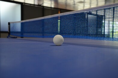 white table tennis ball on blue table tennis table