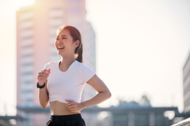 smiling asian young fitness sport woman running  and sportive people training in a urban area, healthy lifestyle and sport concepts