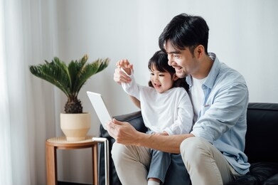 father and daughter at home using a tablet pc