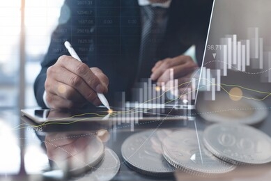 business analysis, finance investment concept. double exposure, businessman working on digital tablet, laptop computer in office and coins money with financial graph, market report on virtual screen