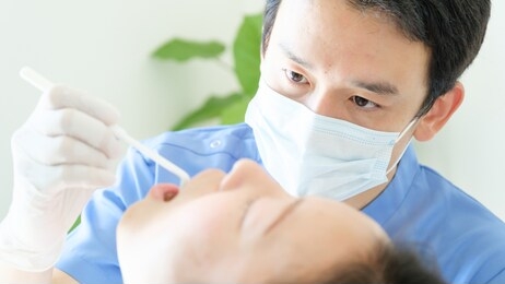 young dentist treating patient teeth at dental hospital