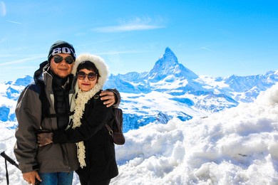 asian senior couple posing with mountain matternhorn in winter season and clear sky	