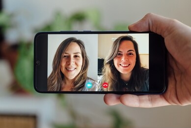 two friends making a video call. hand holding phone while making a video call