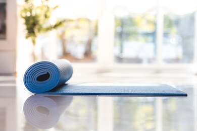 blue yoga mat laid on the floor in the house home exercise concepts, stay home