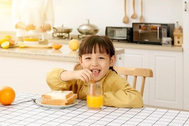 asian little girl eating bread with juice