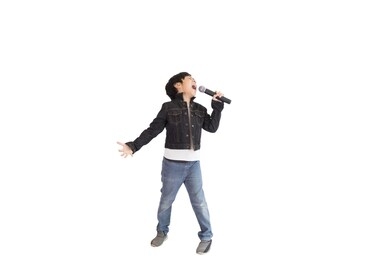 a cute young asian elementary school student enjoying singing. an isolated image with white background.
