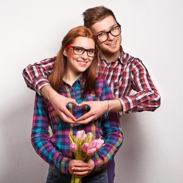 young couple in love make a heart and hands are holding a bouquet of tulips. the concept of valentine's day