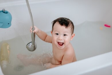 little baby boy, playing in bathtub at home