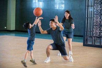 asian family playing basketball together. happy family spending free time together on holiday