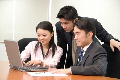 asian business people in business attire working on a notebook pc