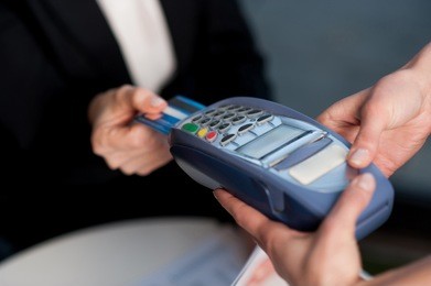 businesswoman swipes her credit card to make the payment