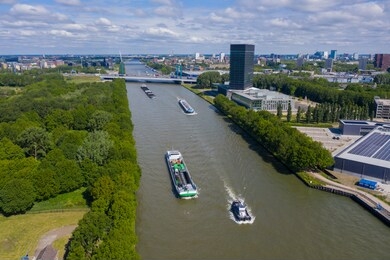 aerial drone footage of canal in the province of utrecht with inland freight ships passing by. the netherlands. inland vessel. in the back is the a12 highway with the prins clausbrug / galecopperbrug