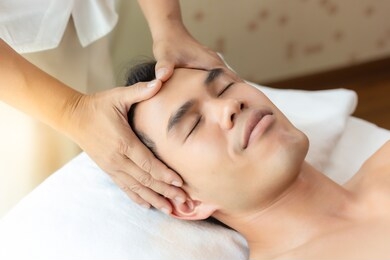 massage therapist massage on male head at spa salon, make customer man get relaxed, relieve stressed from work. asian guy get massage therapy, smile face. worker men smell aromatherapy in spa room