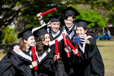 group happy graduates students use mobile phone to take selfie together