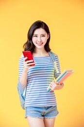 asian female student look to you with smart phone and book