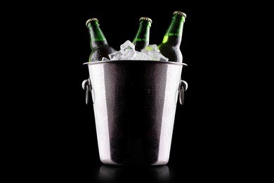 beer bottles in ice bucket isolated on black