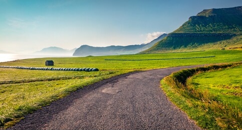haymaking in sydradalur village. colorful morning scene of streymoy island, faroe, kingdom of denmark, europe. beautiful summer seascape of atlantic ocean. traveling concept background.