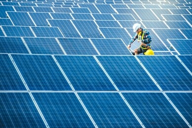 two asian male engineering teams are about to install solar panels. at the solar power generating station asian engineering team ordered and installed solar cells