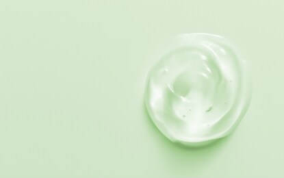 cosmetic gel drop. hand sanitizer, alcohol gel blob on pastel green background. transparent cream swirl. skin care product sample close up