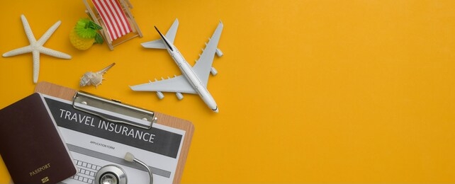 travel insurance concept : travel insurance form on clipboard, stethoscope, passport, decorations and copy space on yellow background 