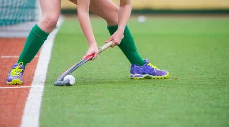 field hockey player, ready to pass the ball to a team mate. hockey is a team game