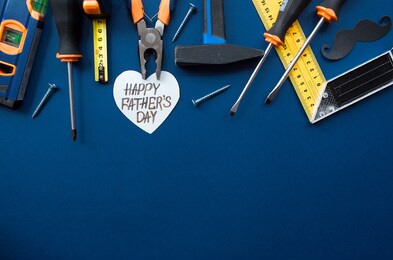 
trendy blue background with tools,
black mustache and heart with the inscription: "happy father's day." give dad a present. happy fathers day concept.