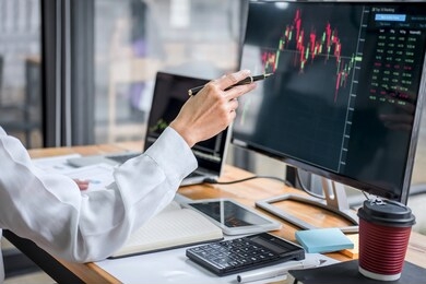 businesswoman working with computer, laptop, thinking and analyzing graph stock market trading with stock chart data planning, financial and investment concept.