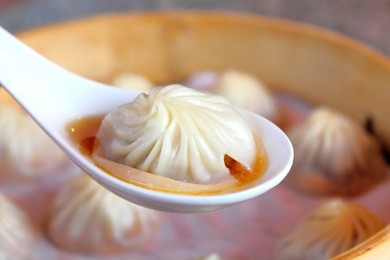 xiao long bao, steamed pork dumplings with soup inside served in bamboo steamer