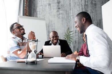 a fascinating discussion of black african american colleagues sitting at the office table in the morning meeting