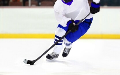 ice hockey player on rink dribbling puck