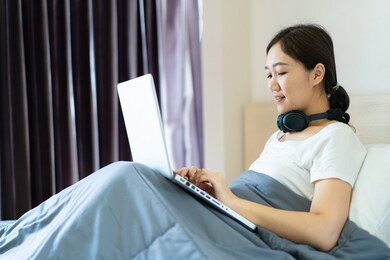 asian young woman's portrait in working at home concept. happy asian woman  using video conference at home. joyful woman browsing the internet.