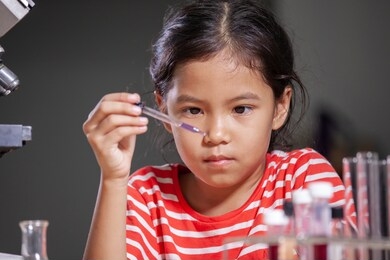 asian child girl making chemical experiment in the laboratory.