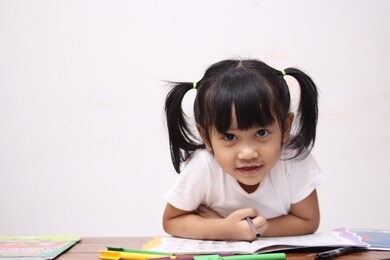 cute adorable little asian baby girl with pony tail hair looking at camera and smiling, happy joy excited expression when learning at home